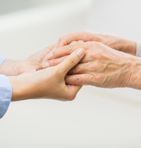 A close-up of a young person and an older person holding each other's hands