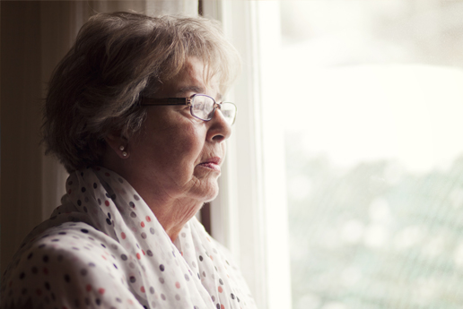 an elderly woman looking out a window
