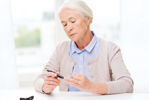 An older woman using a pen to check her blood sugar level