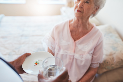 a domiciliary care service user with their carer holding a plate of pills
