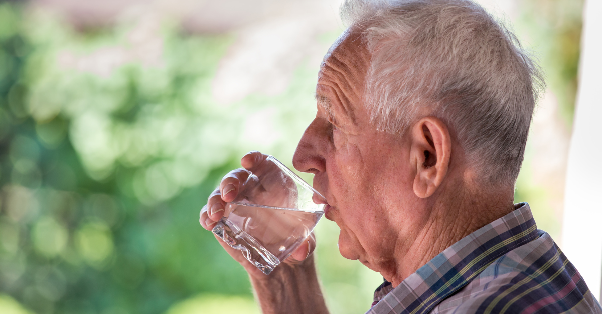 male older adult drinking water during hot weather