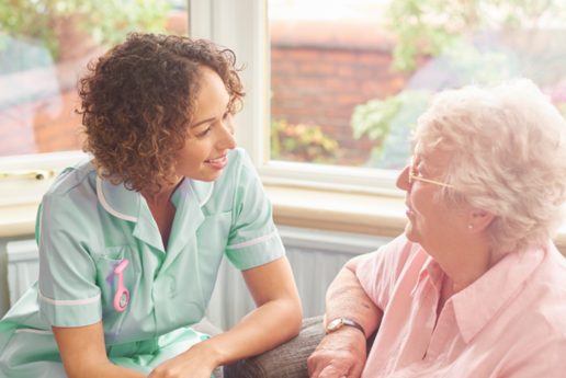 A female care worker talking to an elderly woman