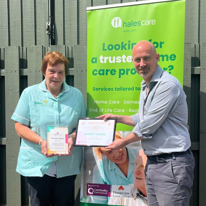 a photo of neil eastwood, care friends ceo and founder, presenting the 2023 care friends top referring care worker award to hales care worker wendy